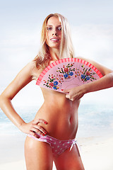 Image showing woman holding fan on beach