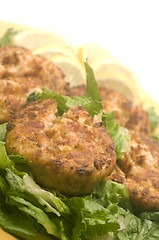 Image showing lobster cakes  bed of lettuce with lemon slice wedges