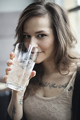 Image showing Young Woman Drinking a Pint Glass of Ice Water