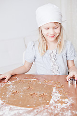 Image showing Happy young girl making gingerbread