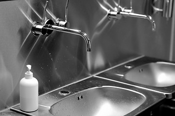 Image showing faucets, sinks and liquid soap in a toilet