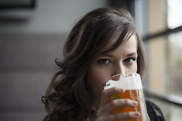 Image showing Young Woman Drinking a Pint Glass of Pale Ale