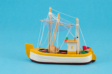 Image showing wooden handmade boat ship model on blue background 