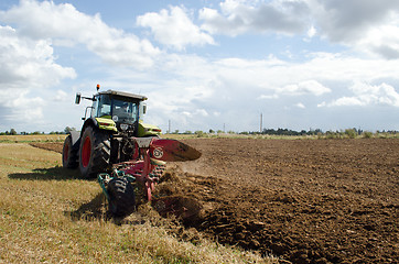 Image showing heavy agricultural machine tractor works in field 