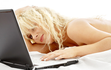 Image showing portrait of blond laying in bed with laptop