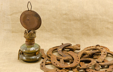 Image showing retro kerosene lamp rusty horse shoes linen 