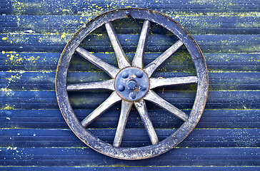 Image showing Blue wall with blue cart wheel