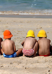 Image showing Three cute small children playing on the beach