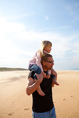 Image showing Father carrying daughter on shoulders at the beach