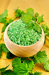 Image showing Salt green in a wooden bowl with nettles on the board