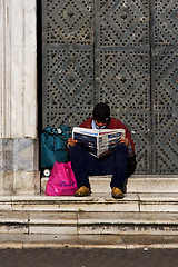 Image showing naples and a hompless reading a newspaper