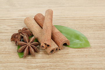 Image showing Star Anise, cinnamon and and green leave on wood