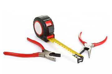 Image showing red pliers and measuring tape isolated on white