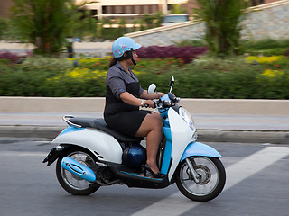 Image showing Thai woman rides a scooter. Editorial only.