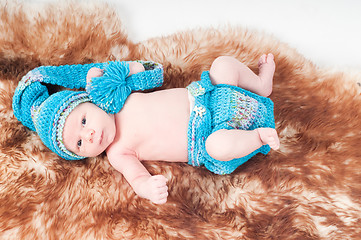 Image showing Newborn baby in knitted blue clothes