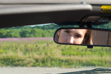 Image showing Brunette woman watching on rear-view mirror