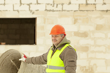 Image showing Builder at the new building near the concrete mixer