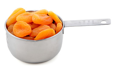 Image showing Whole dried apricots presented in an American metal cup measure