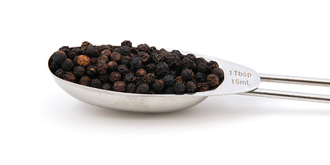 Image showing Black peppercorns measured in a metal tablespoon