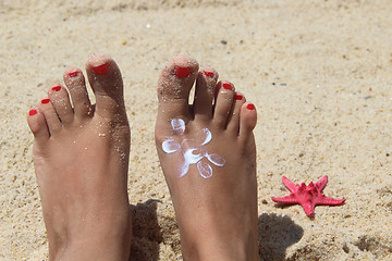 Image showing Female feet on the beach