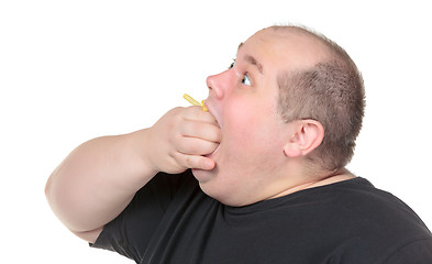 Image showing Fat Man Greedily Eating French Fries