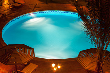 Image showing Nighttime setting of a luxury villa poolside