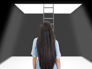 Image showing woman standing in a pit looking up to the ladder that leads out 