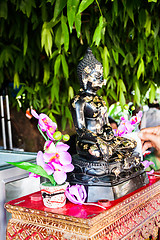 Image showing Buddhist covering buddha image with gold leafs