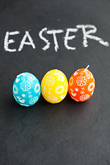 Image showing Colorful Easter egg shaped candles and text