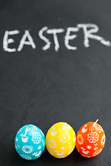 Image showing Colorful Easter egg shaped candles and text