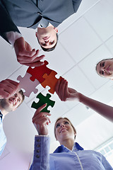 Image showing Group of business people assembling jigsaw puzzle