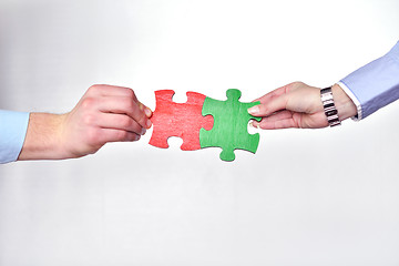 Image showing Group of business people assembling jigsaw puzzle