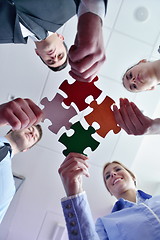 Image showing Group of business people assembling jigsaw puzzle