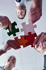 Image showing Group of business people assembling jigsaw puzzle