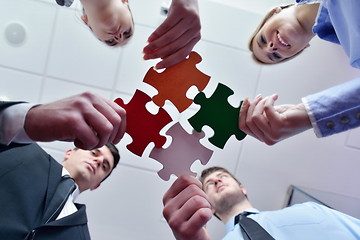 Image showing Group of business people assembling jigsaw puzzle