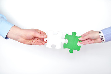 Image showing Group of business people assembling jigsaw puzzle