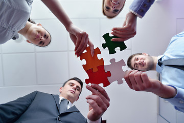 Image showing Group of business people assembling jigsaw puzzle