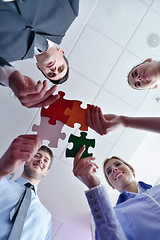 Image showing Group of business people assembling jigsaw puzzle