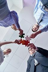 Image showing Group of business people assembling jigsaw puzzle