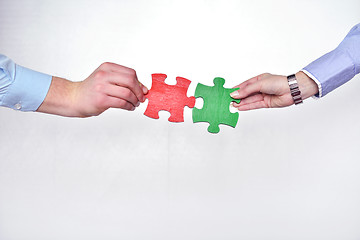 Image showing Group of business people assembling jigsaw puzzle