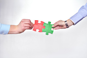 Image showing Group of business people assembling jigsaw puzzle