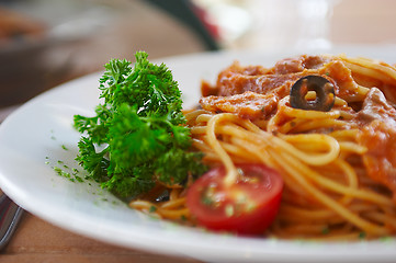 Image showing Spaghetti with a tomato sauce on a table in cafe 