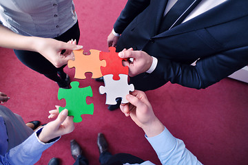 Image showing Group of business people assembling jigsaw puzzle