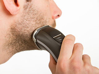 Image showing Young man shaving his beard off