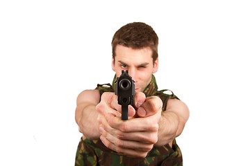 Image showing Soldier in camouflage vest is holding a gun