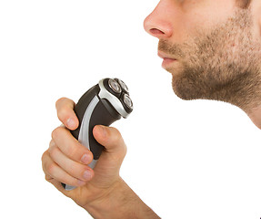 Image showing Young man shaving his beard off