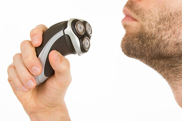 Image showing Young man shaving his beard off