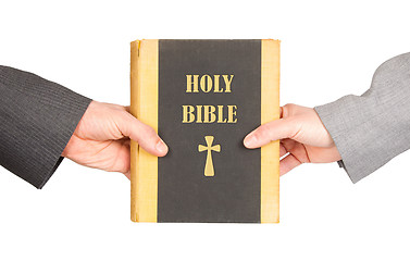 Image showing Man and woman in business suits are holding a holy bible