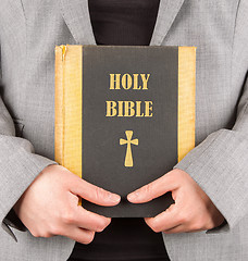 Image showing Woman in business suit is holding a holy bible