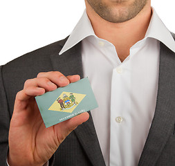 Image showing Businessman is holding a business card, Delaware